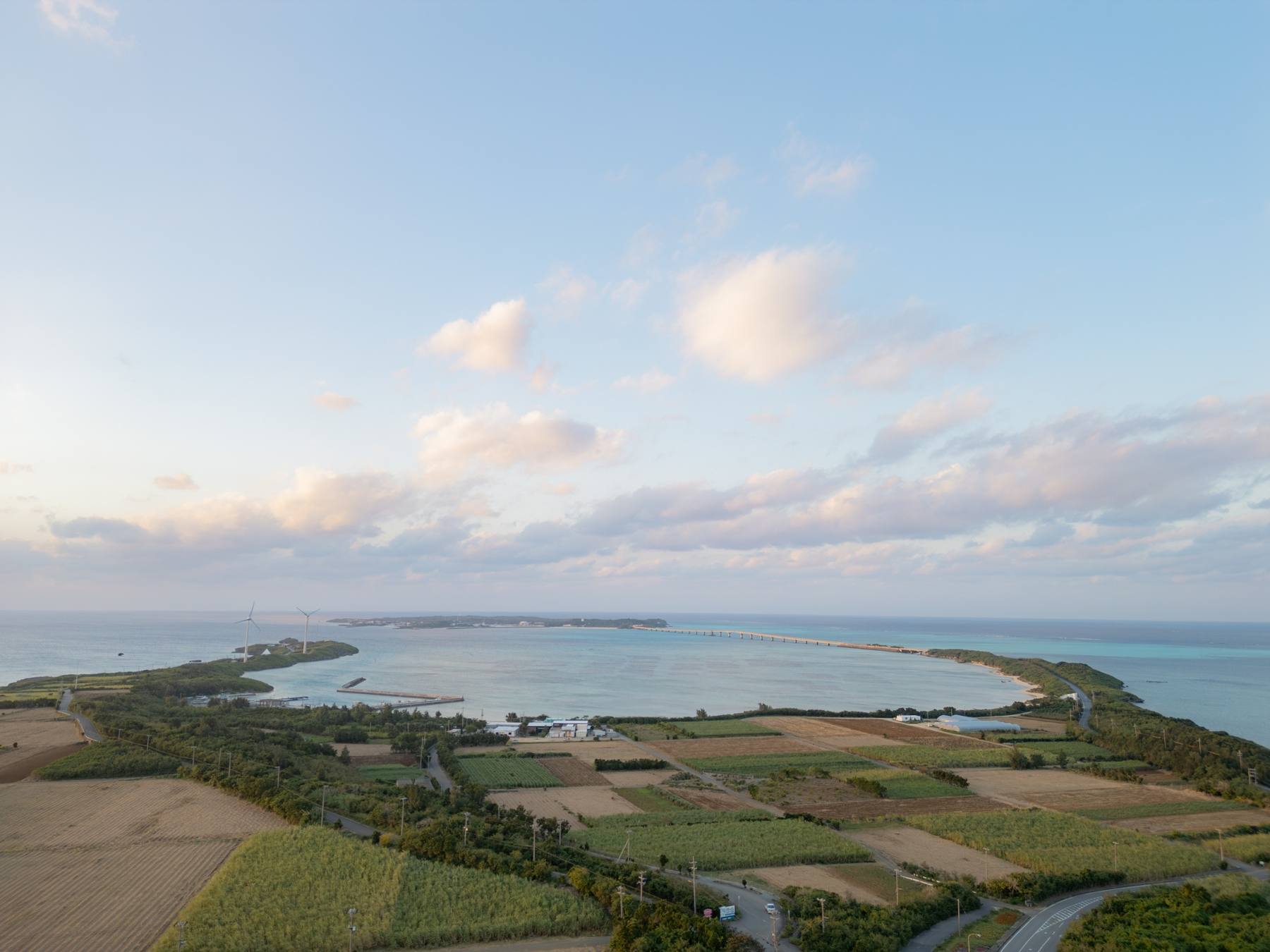 夕暮れの狩俣集落と海。宮古島北部の集落を空から見た風景